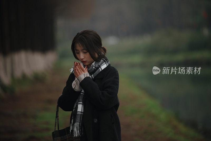 亚洲女孩走在河边的雨天