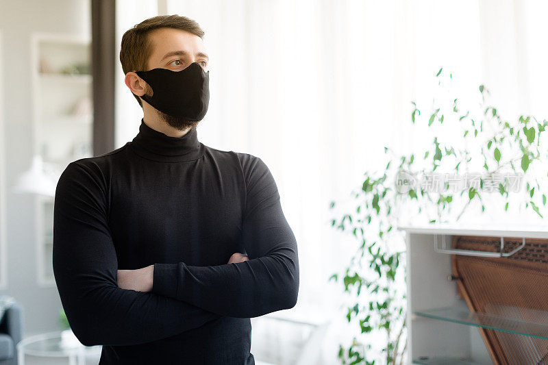 成年男子在室内佩戴可重复使用的医用面部防护口罩的肖像。新冠肺炎疫情后的新常态为经营理念