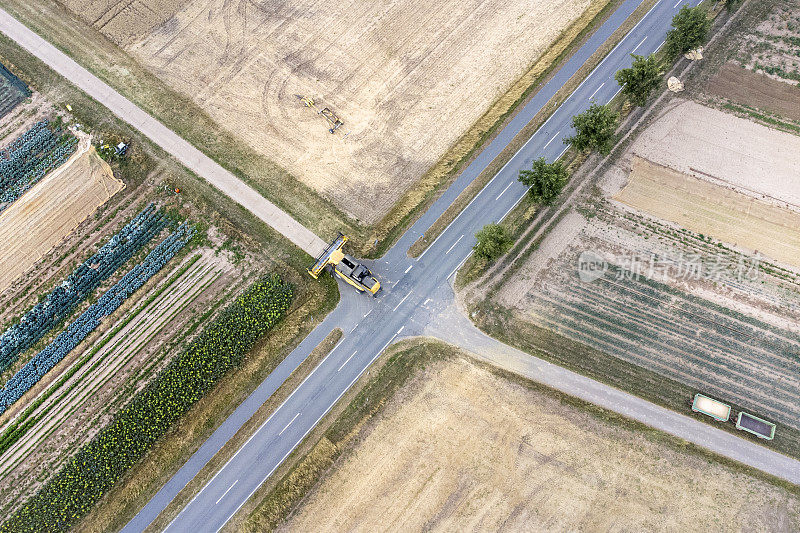 一辆联合收割机正穿过一条乡村公路——鸟瞰图