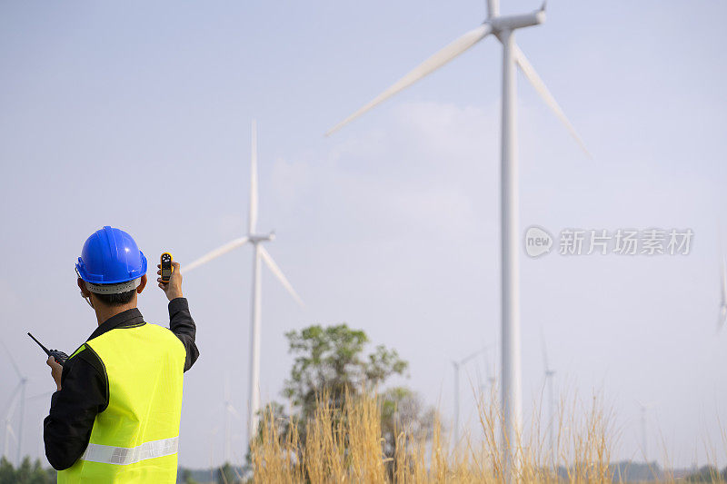 电力工地的蓝领工人。风车。