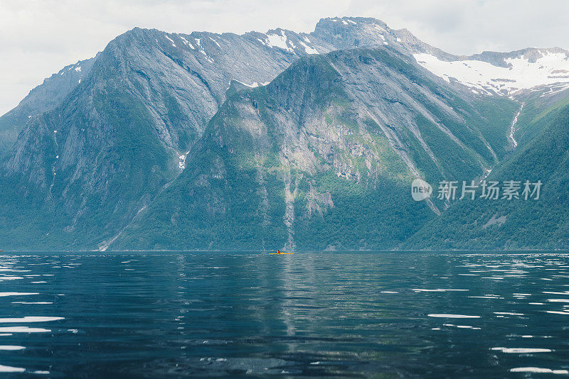 一名游客在挪威风景优美的峡湾上享受夏日的皮划艇