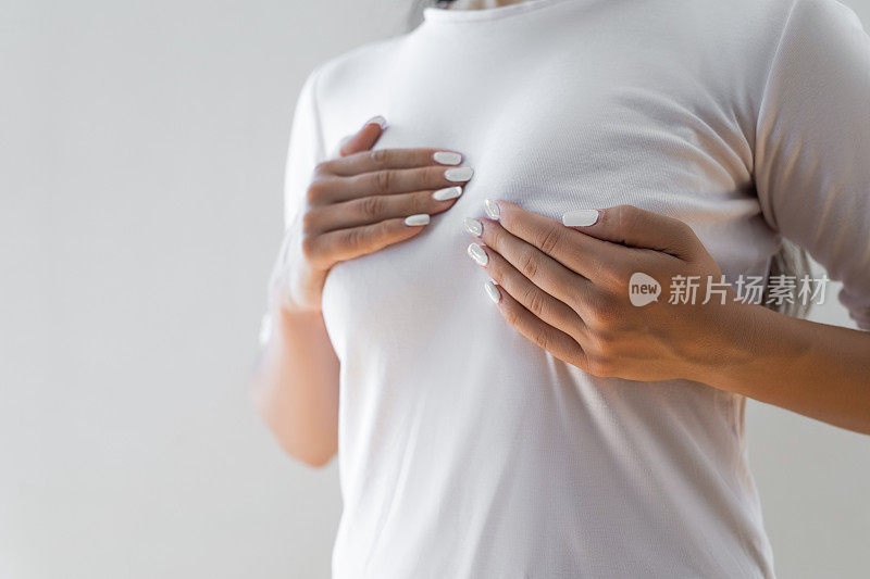 一名妇女正在检查乳房上的肿块，以寻找乳腺癌的迹象