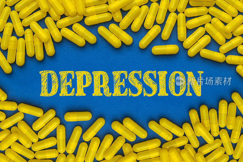 黄字凹陷，蓝色底色上有许多黄色药丸，平铺。医学和心理健康概念。