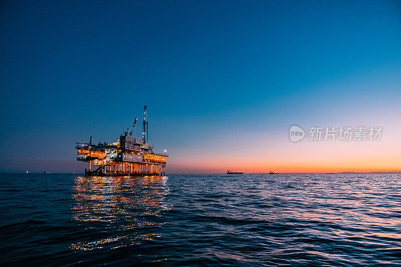 海上石油钻井平台在亨廷顿海滩附近的太平洋夕阳反射，加利福尼亚与复制空间