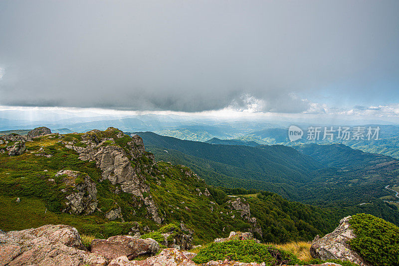 在一个阳光明媚的夏日里，有美丽的山峦和岩石景观。