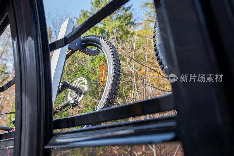 mtb自行车的车轮悬挂在山缆车的马车外，通过打开的窗口看到的贡多拉。美丽的秋天，阳光明媚的日子。冒险。