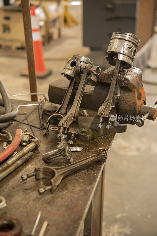 旧的，损坏的活塞连杆倾斜和安装在虎钳拆卸在机械师的车库里