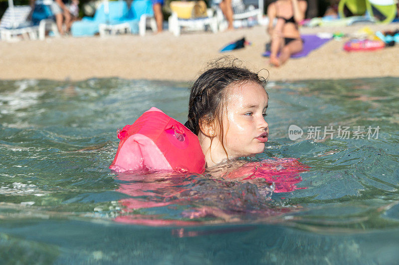 小女孩在海里游泳。