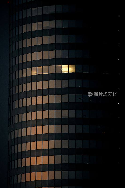 垂直拍摄的现代圆形建筑在夜间，光线从窗户照射