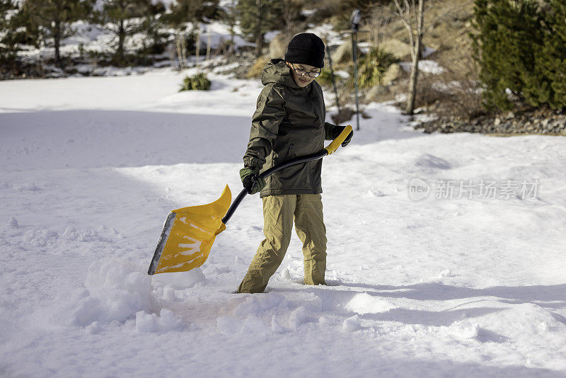 男孩在家里铲雪