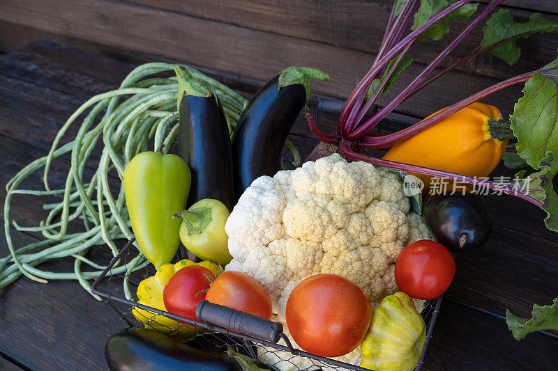 黑色木桌上的有机农场蔬菜。新鲜的生菜花，四季豆，西葫芦，玉米，甜菜。副本的空间。