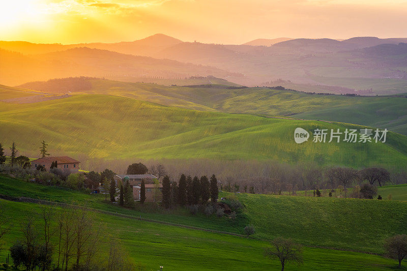 日出在意大利托斯卡纳乡村山中间的一个孤独的农场