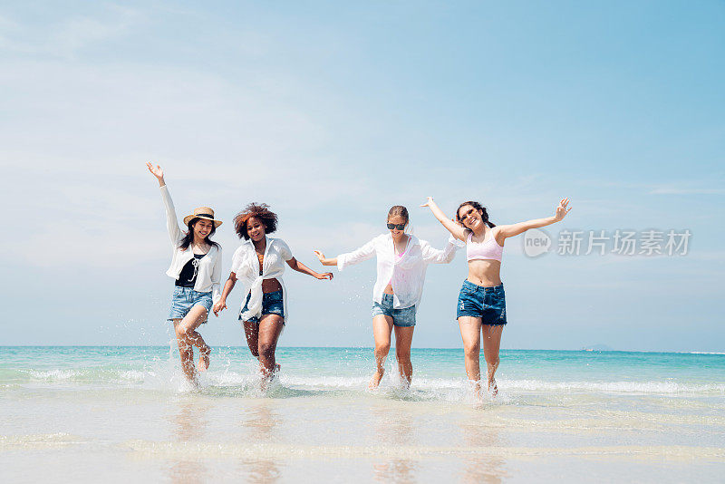 快乐的青少年在海滩聚会一起在海滩上玩在一个阳光明媚的日子，海滩暑假海人的概念
