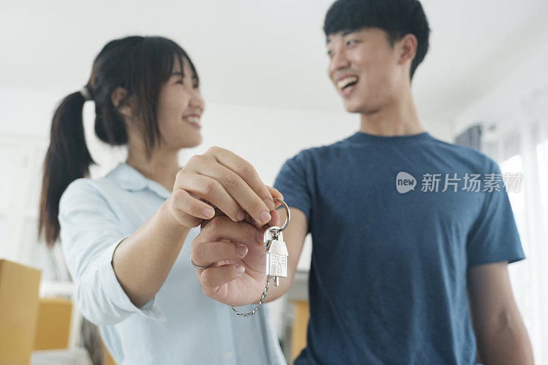 幸福的年轻夫妇买了新房子，收到了钥匙。