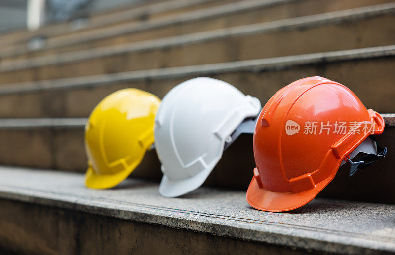 建筑工人，工程师，技术人员，在建筑工地工作的检查员的头盔。工作时戴上安全帽，防止事故发生。蓝领工人的工作设备-库存照片