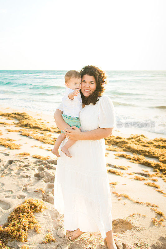 2023年春天，佛罗里达州棕榈滩，一位31岁的古巴母亲抱着她1岁的儿子在沙滩上享受金色日出的时光
