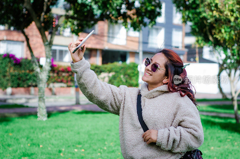 哥伦比亚女子在街上用智能手机自拍的照片