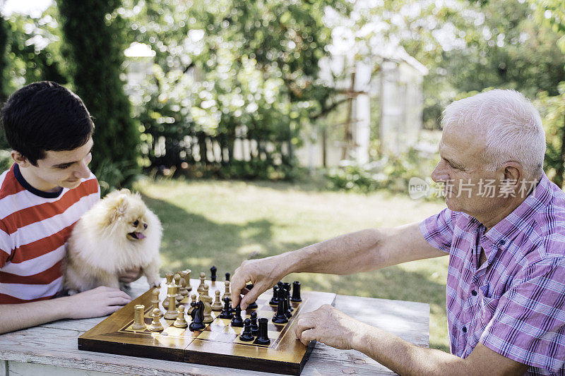 爷爷和孙子在一起下棋。