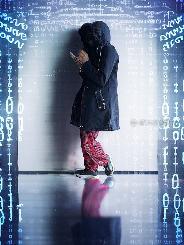 形象男，亚裔，秘密电脑黑客程序员，穿着雨衣戴着兜帽，编程电脑代码背景，网络战争黑客技术，加密编码，网络犯罪，软件编程，数字数据分析，网络犯罪概念