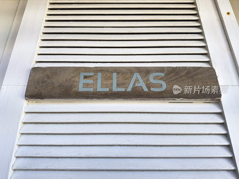 一扇白色的门上挂着一个牌子，上面写着西班牙语“ellas”