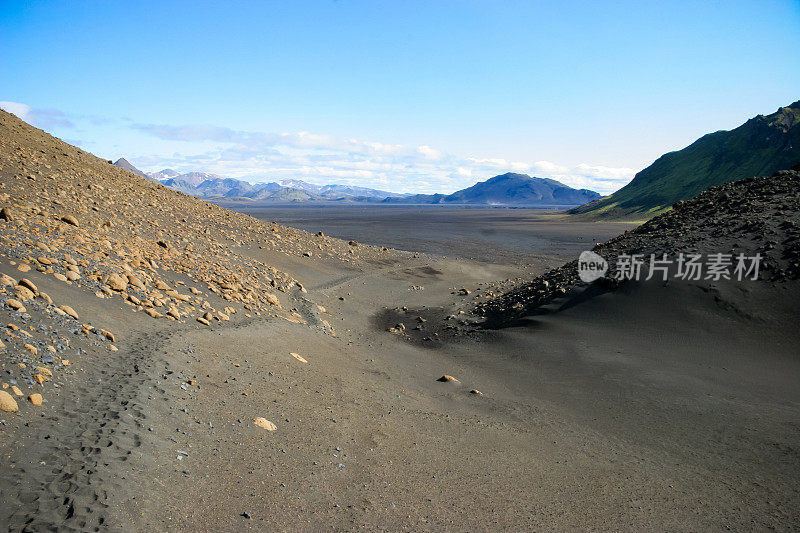 在到达Thorsmork之前，在冰岛的Laugevegur徒步旅行中，一个广阔的沙漠平原伸展开来，这是一个典型的场景