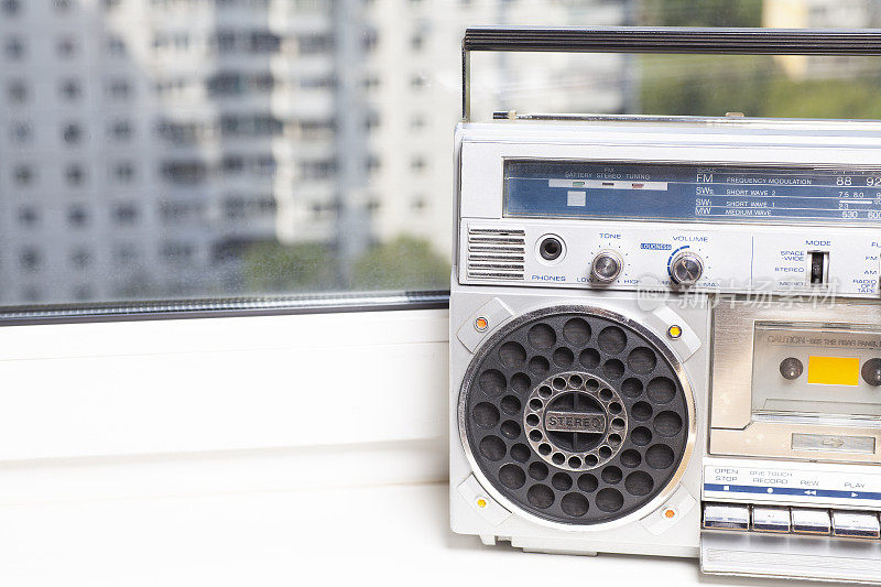 窗台上放着80年代的银色复古贫民窟收音机盒式录音机