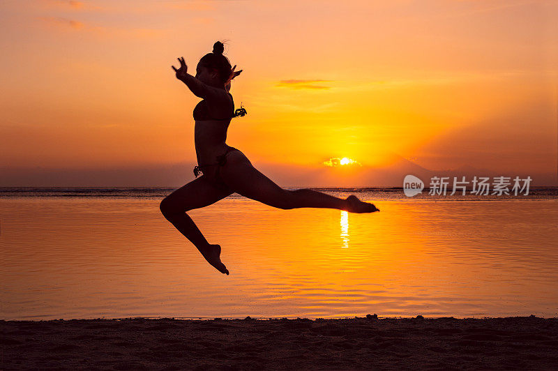 年轻女子在巴厘岛海滩日落