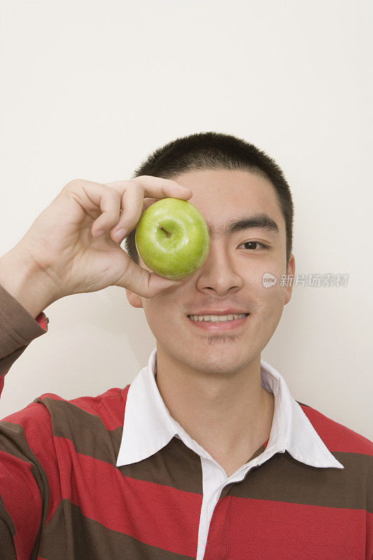 一个中国人拿着苹果