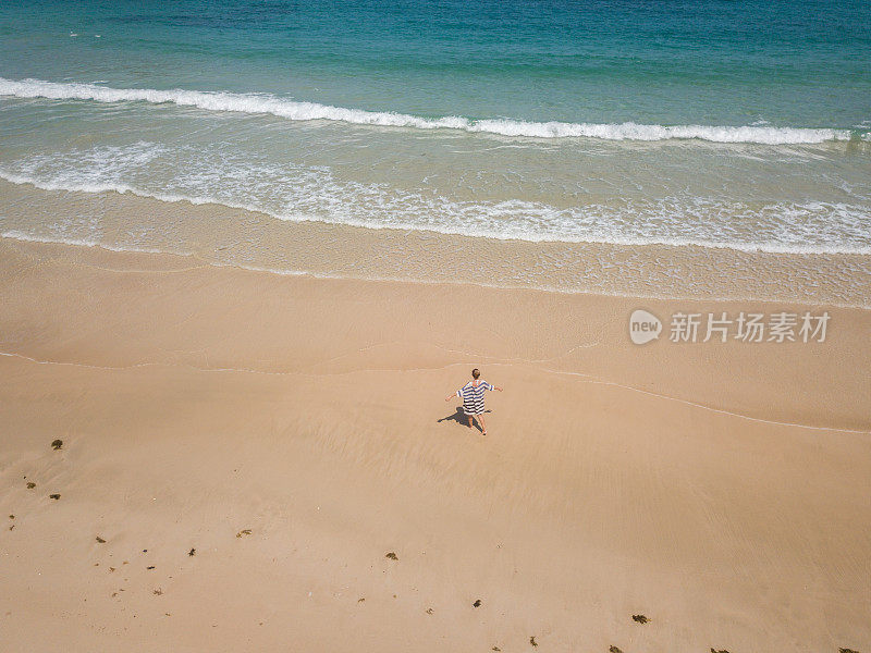 无人机的观点，年轻的女人在热带海滩上伸开双臂拥抱自由和度假天堂。人岛旅游目的地概念