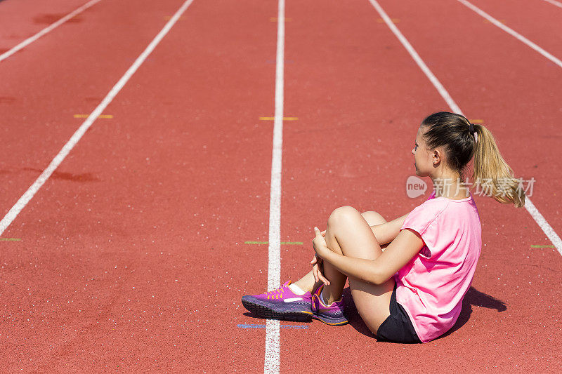 女运动员在跑道上腿部关节疼痛
