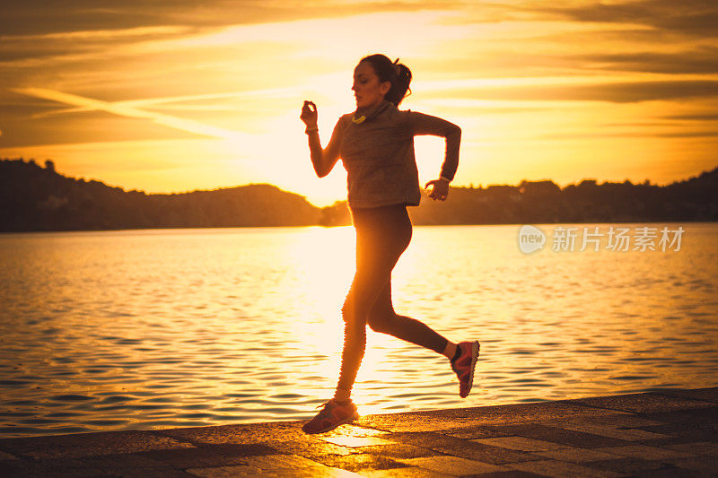 日落时分在海边跑步的女人