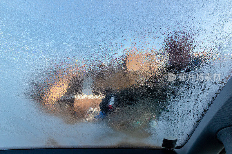 高年级学生用一瓶防冻剂给车窗除冰。