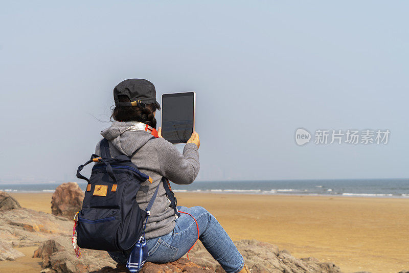 年轻女性在海滩上素描