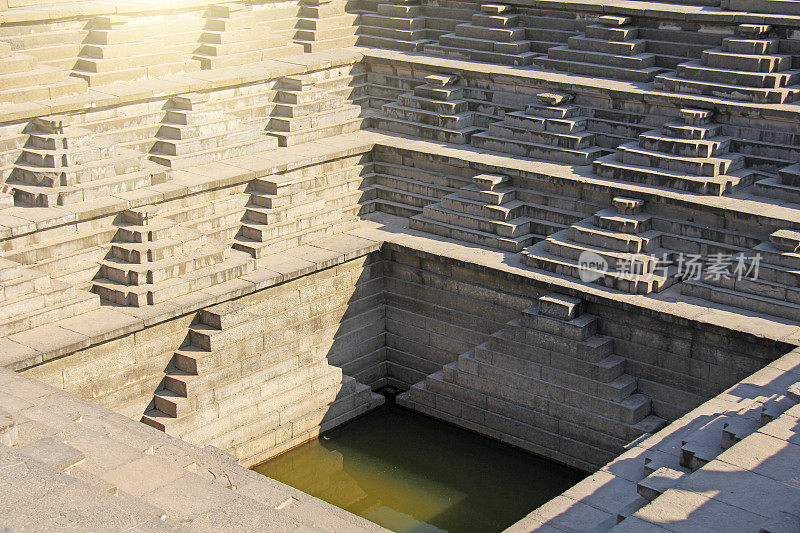 印度卡纳塔克邦汉普比的普什卡拉尼，装有绿色水的梯级水箱。皇后区浴。背景几何