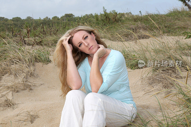 一只雌性只坐在海滩上或附近。