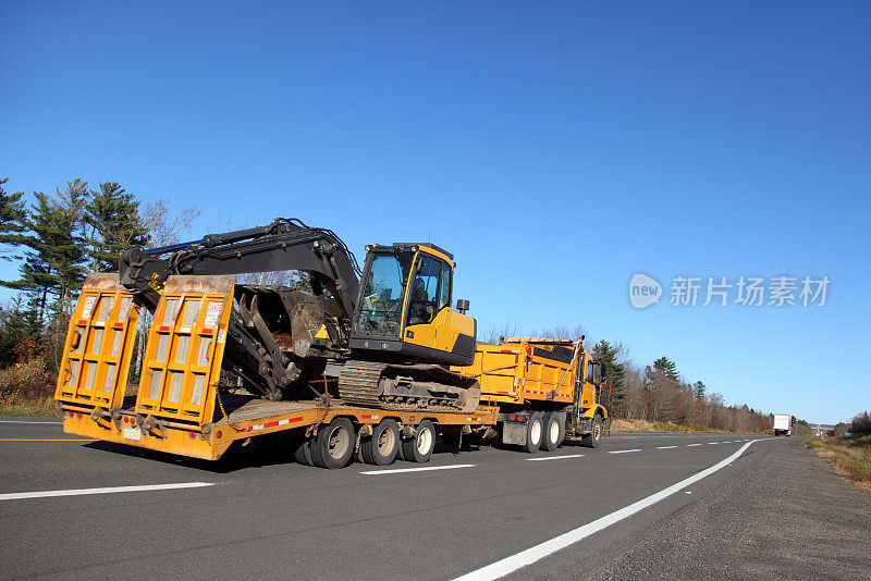 公路上一辆带拖车的自卸卡车。