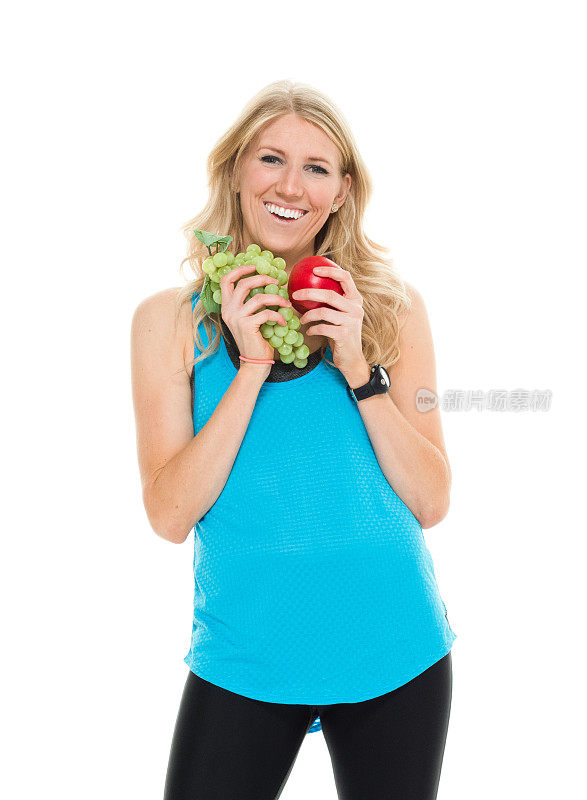 兴高采烈的女运动员拿着水果