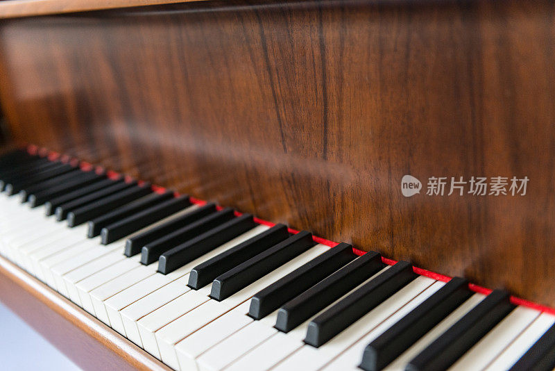 钢琴键盘上的棕色木制钢琴在近距离的照片
