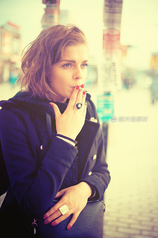 沉思的女人在街上抽烟