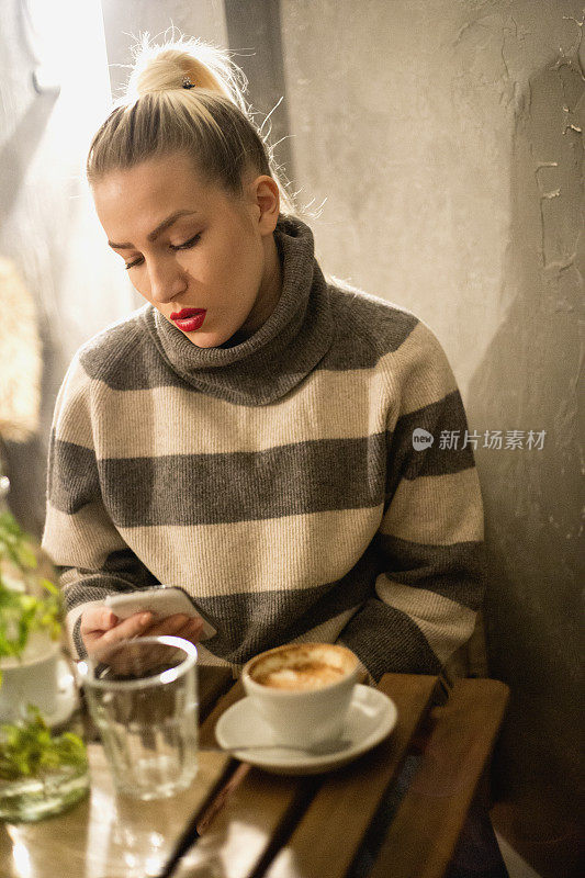 女孩在咖啡馆里喝着咖啡