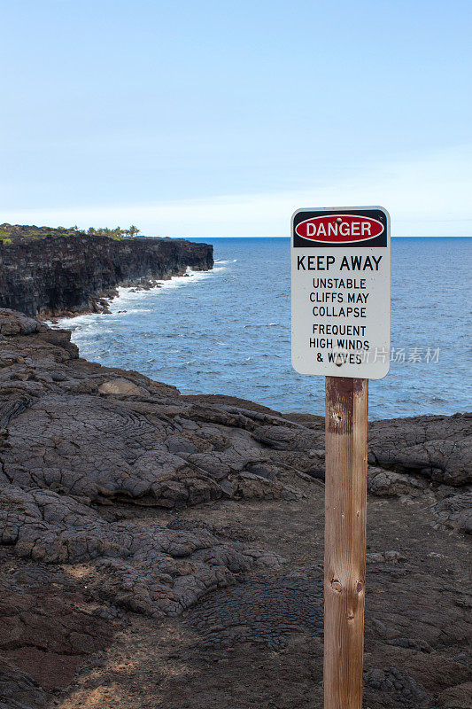 黑色熔岩悬崖和警告标志