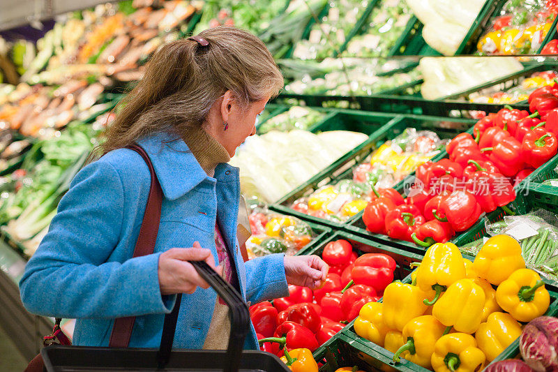 购物:成熟的女人选择新鲜的蔬菜