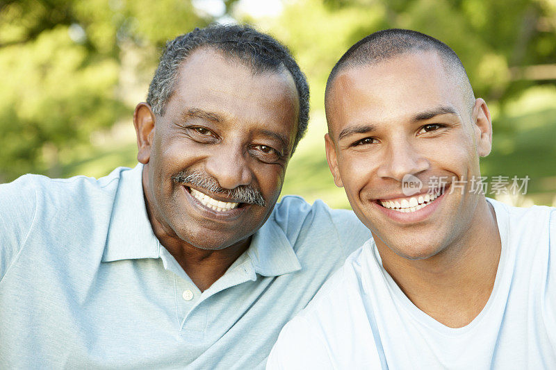 非裔美国父亲和成年的儿子在公园里放松