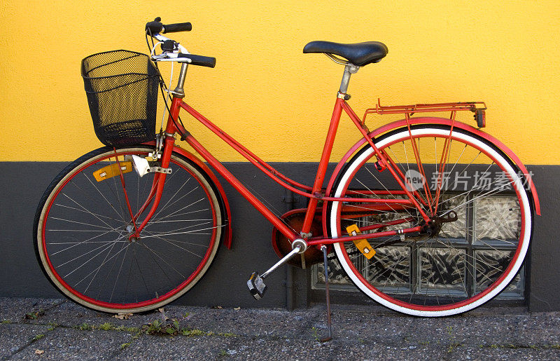 红色的自行车。黄色的墙。