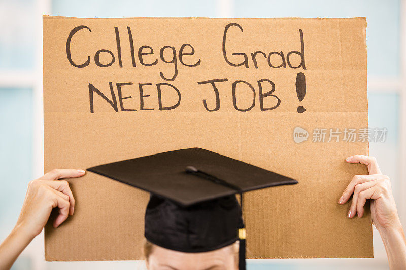 教育背景:大学生举着“大学毕业生需要工作”的牌子。