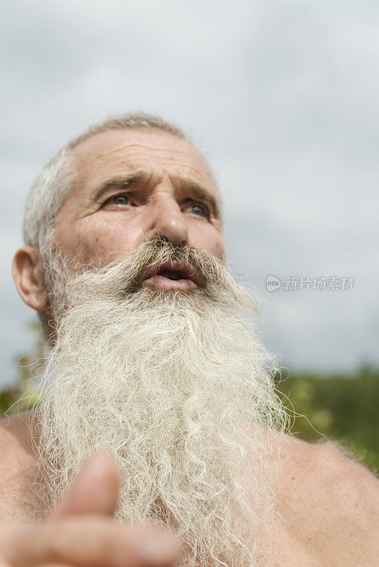 一个长着白胡子的老人在田野里说话