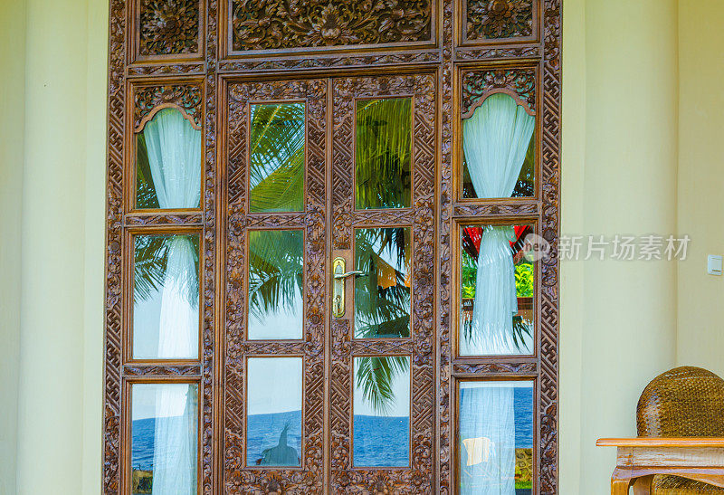 门上有玻璃和带有热带镜的木雕