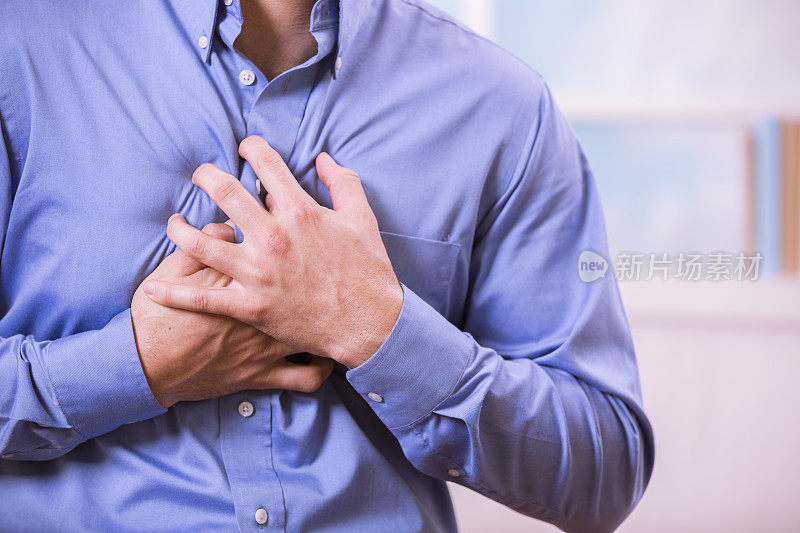 医疗保健:一名男子痛得捂着胸口，可能是心脏病发作。