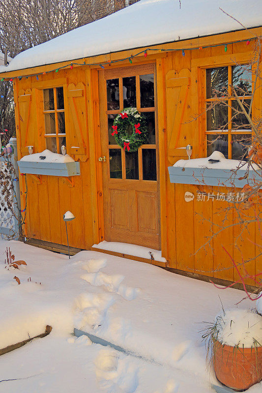 古色古香的花园小屋在冬天覆盖着圣诞节的雪