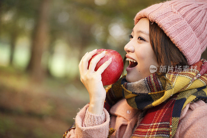 快乐的年轻女子正在吃苹果